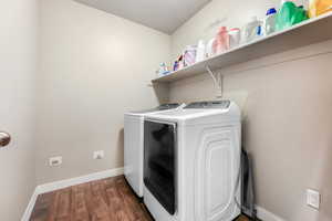 Laundry area featuring separate washer and dryer and dark wood-type flooring