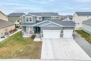 View of front of property with a garage, covered porch, and a front yard