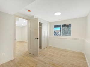 Empty room featuring light wood-type flooring and a textured ceiling