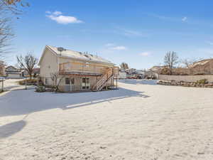 Snow covered house featuring a wooden deck