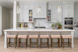 Kitchen with a center island with sink, a breakfast bar, and stainless steel double oven