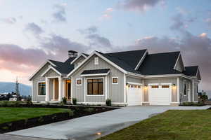 View of front facade featuring a mountain view, a yard, and a garage