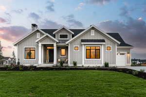 View of front of house featuring a porch, a garage, and a lawn