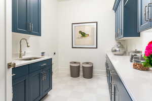 Clothes washing area featuring washer hookup, sink, cabinets, and hookup for an electric dryer