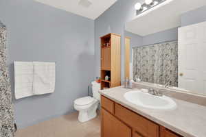 Bathroom featuring tile patterned flooring, vanity, and toilet