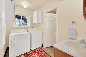 Laundry area with washing machine and dryer and sink