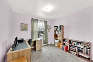 Office space with carpet flooring and a textured ceiling