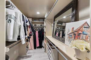 Spacious closet featuring light hardwood / wood-style flooring