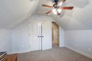 Bonus room featuring light colored carpet, vaulted ceiling, and ceiling fan