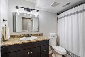 Bathroom with vanity, a textured ceiling, and toilet