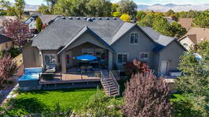 Rear view of house with a mountain view and a yard