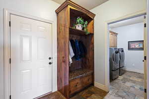 Laundry area featuring washing machine and clothes dryer and cabinets