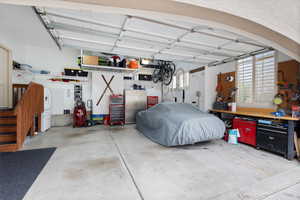 Garage with a workshop area and stainless steel fridge