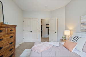 Bedroom featuring light colored carpet and a closet