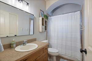 Bathroom featuring walk in shower, tile patterned floors, vanity, and toilet