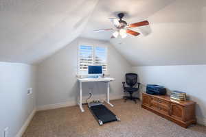 Office area with light carpet, a textured ceiling, ceiling fan, and lofted ceiling