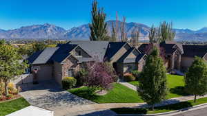 View of front of property featuring a mountain view, a garage, and a front yard