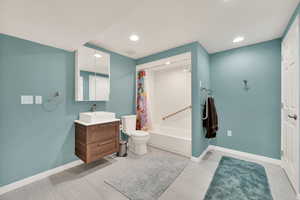 Full bathroom featuring vanity, toilet, and shower / bath combo with shower curtain