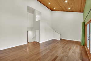 Family room with light wood-type flooring, high vaulted ceiling, plenty of natural light, and wooden ceiling