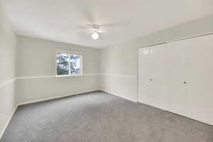 Bedroom featuring ceiling fan, carpet floors, and a closet