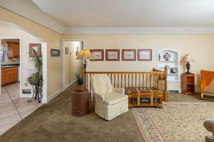 Living area featuring built in shelves and light tile patterned flooring