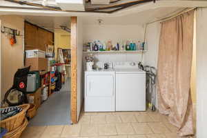 Washroom featuring separate washer and dryer and light tile patterned floors