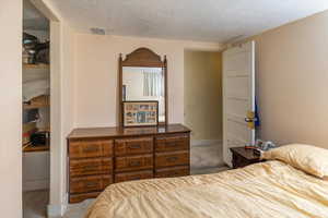 Bedroom with carpet flooring and a textured ceiling