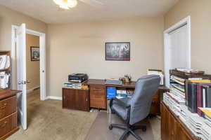 Home office featuring ceiling fan and light colored carpet