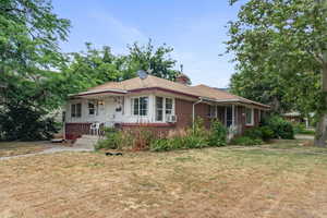 Single story home featuring cooling unit, covered porch, and a front yard