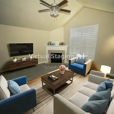 Living room featuring ceiling fan, a fireplace, and lofted ceiling