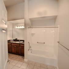 Bathroom with tile patterned flooring, vanity, and  shower combination