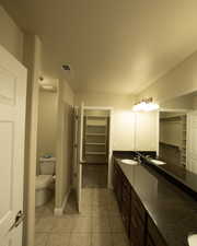 Bathroom featuring tile patterned flooring, vanity, and toilet