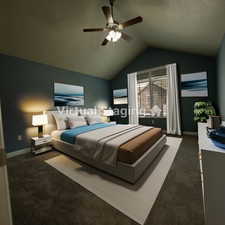 Carpeted bedroom with ceiling fan and vaulted ceiling