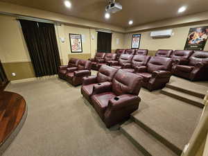 Carpeted home theater with a wall mounted air conditioner