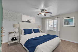 Bedroom with carpet flooring, ceiling fan, and a textured ceiling