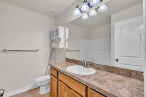 Bathroom featuring tile patterned flooring, vanity, and toilet