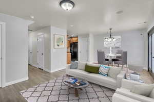 Living room with light hardwood / wood-style floors and an inviting chandelier