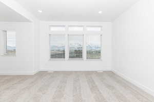 Empty room featuring light colored carpet and plenty of natural light