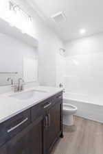 Full bathroom featuring shower / bath combination, vanity, toilet, and wood-type flooring