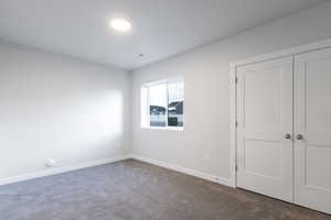 Unfurnished bedroom with carpet flooring and a closet