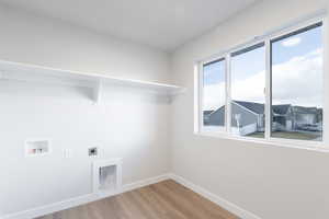 Laundry area featuring hardwood / wood-style flooring, electric dryer hookup, and hookup for a washing machine