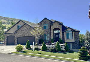 French country style house featuring brick siding, driveway, a front yard, and a garage