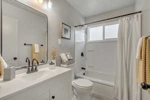 Full bathroom featuring tile patterned floors, vanity, toilet, and shower / tub combo