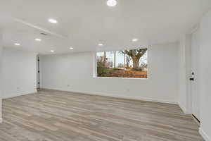 Basement living room with light wood-type flooring