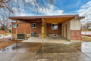 Rear view of house with a carport and new A/C unit and back entrance