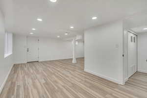 Basement living room with light hardwood / wood-style flooring