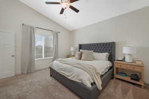 Bedroom featuring carpet, ceiling fan, and vaulted ceiling