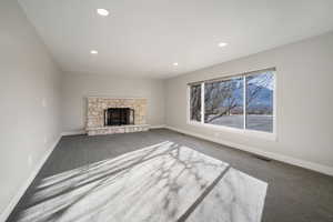 Living room featuring a gas fireplace and carpet flooring, large picture window with views of the cul-de-sac rim overlooking Provo’s Rock Canyon