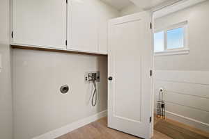 Laundry area with hookup for a washer/dryer (electric) and storage cabinets