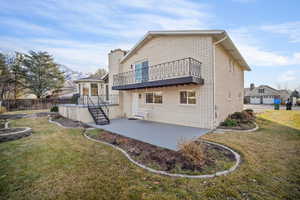 Rear view of property featuring multi-level patio, dining nook, primary balcony, fire pit and yard landscaping